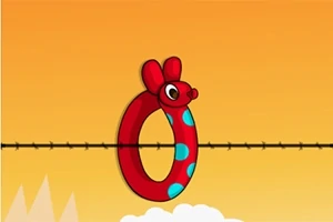 En röd musformad ring med blå prickar balanserar på en vajer mot en orange himmel