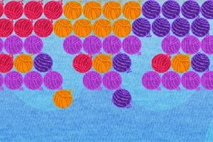 Färgade bollar i rött, orange, lila, och blått mot en blå bakgrund