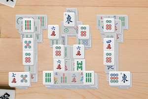 Mahjongbrickor staplade i komplexa formationer på ett träbord