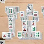 Mahjongbrickor staplade i komplexa formationer på ett träbord