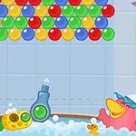 Färgglada bollar hänger i övre delen, och två animerade fågelliknande figurer med accessoarer badar bland bubblor, tillsammans med en flytande badanka