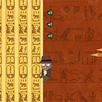En tecknad man med hatt klättrar på en vägg dekorerad med egyptiska hieroglyfer, bredvid gröna ädelstenar och spjutspetsar