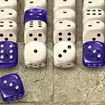 Vita och blå tärningar arrangerade i rader på en ojämn stenliknande yta